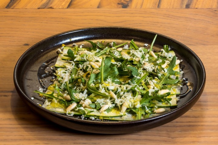 a bowl full of broccoli sitting on top of a wooden table
